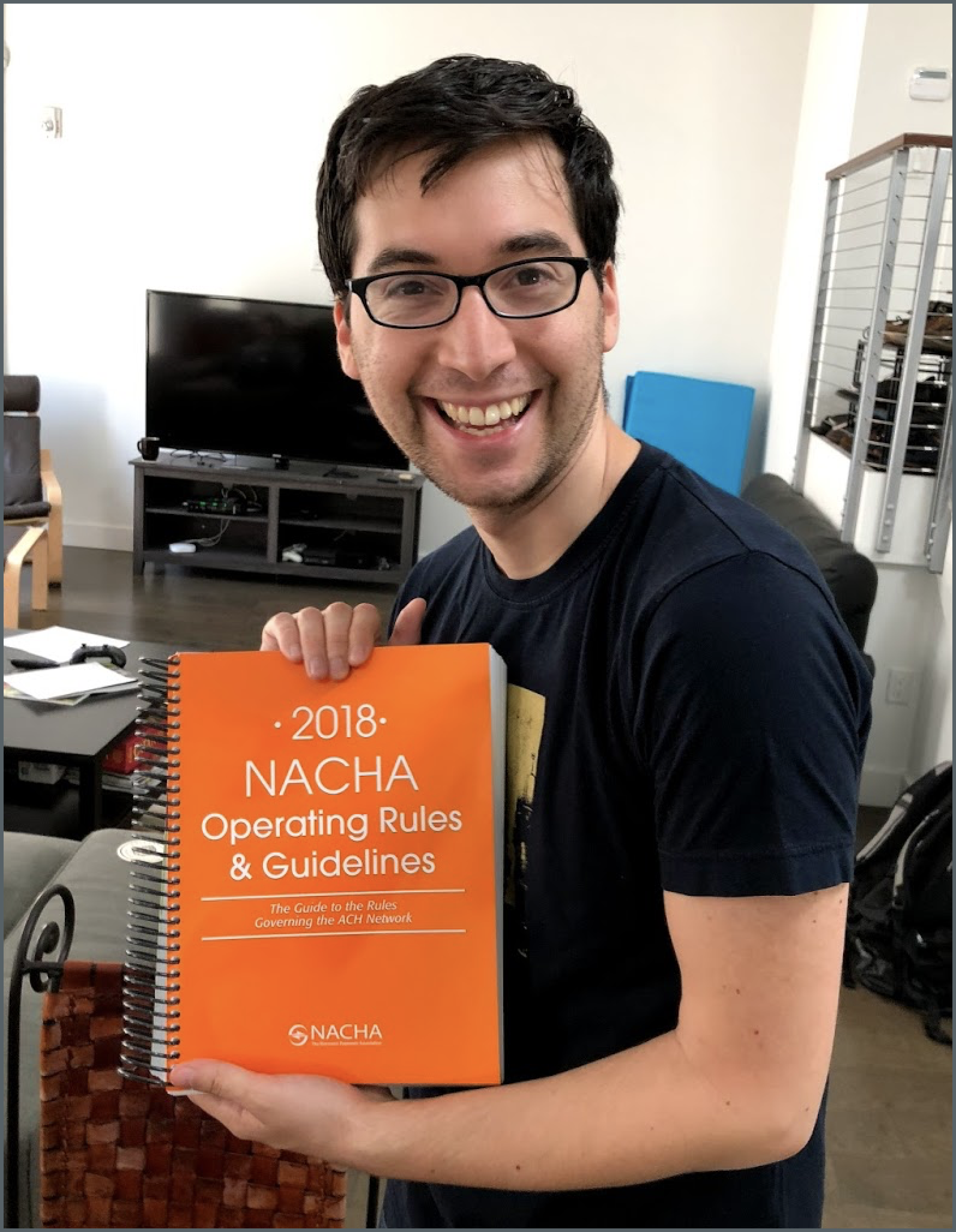 Co-founder Sam Aarons holding up the 2018 NACHA Operating Rules & Guidelines