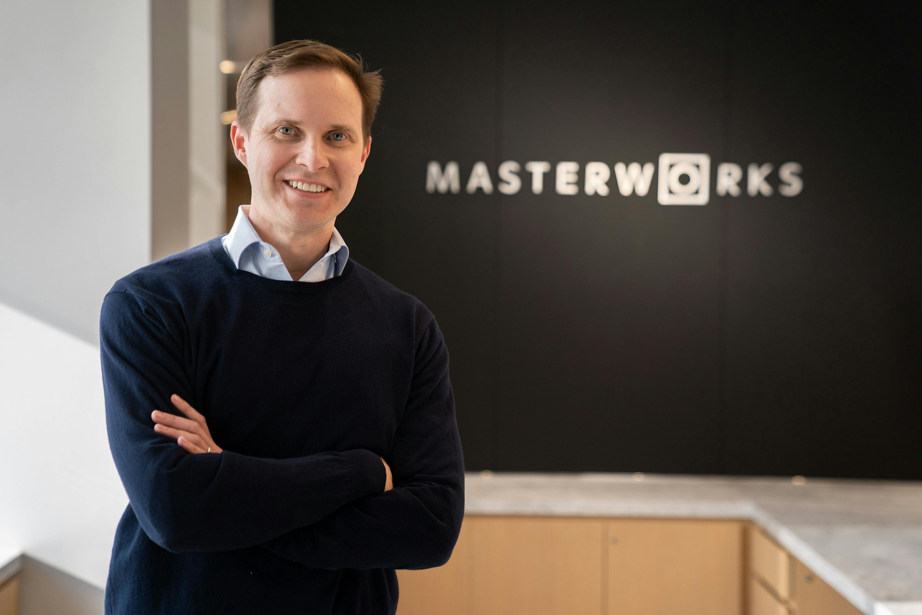 Masterworks CFO Nigel Glenday standing in front of the Masterworks logo