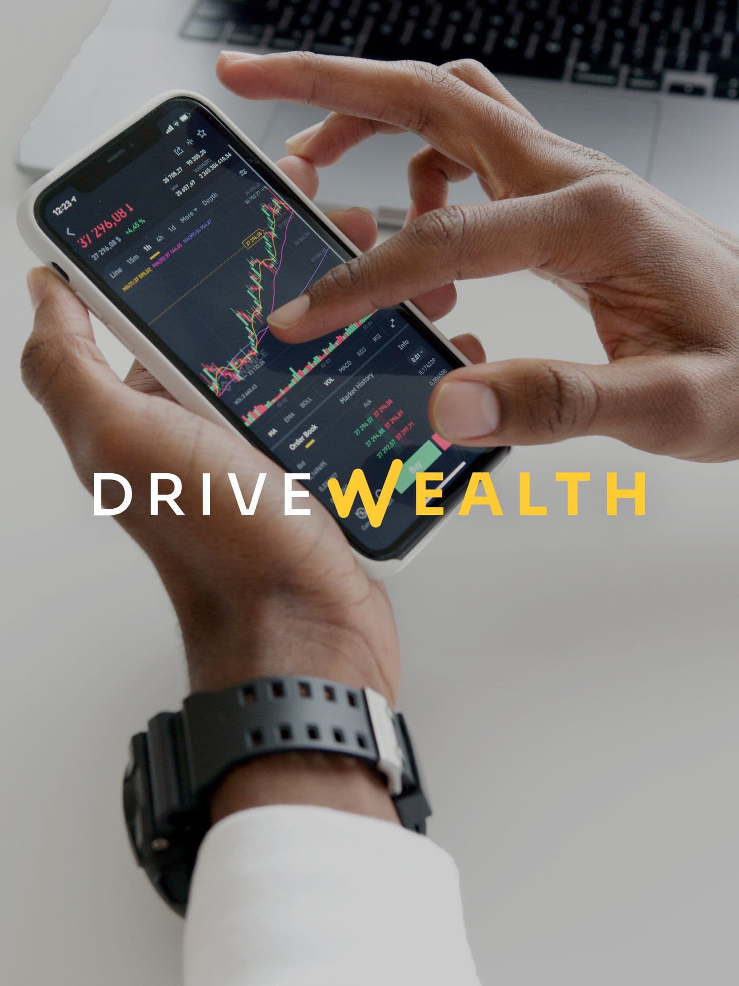 A professional man looking at paperwork beside a computer with the DriveWealth logo on top of the image